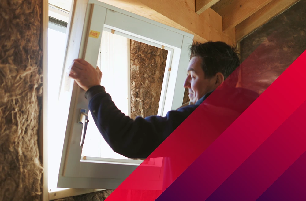 Ein Handwerker montiert ein Fenster in einer Holzwerkstatt.