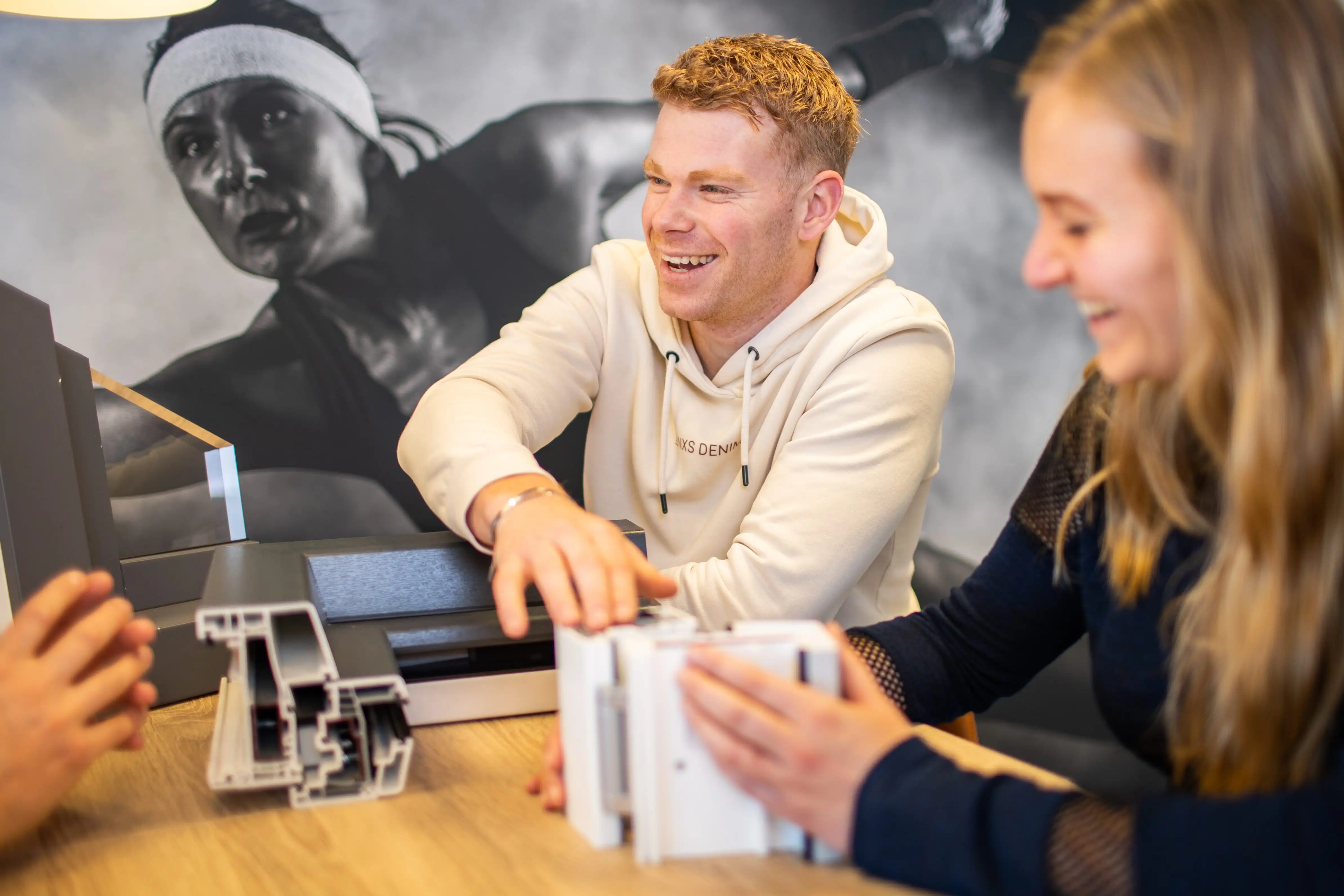Beratungsgespräch mit Kunden, die Fenster- und Türprofile im Showroom vergleichen